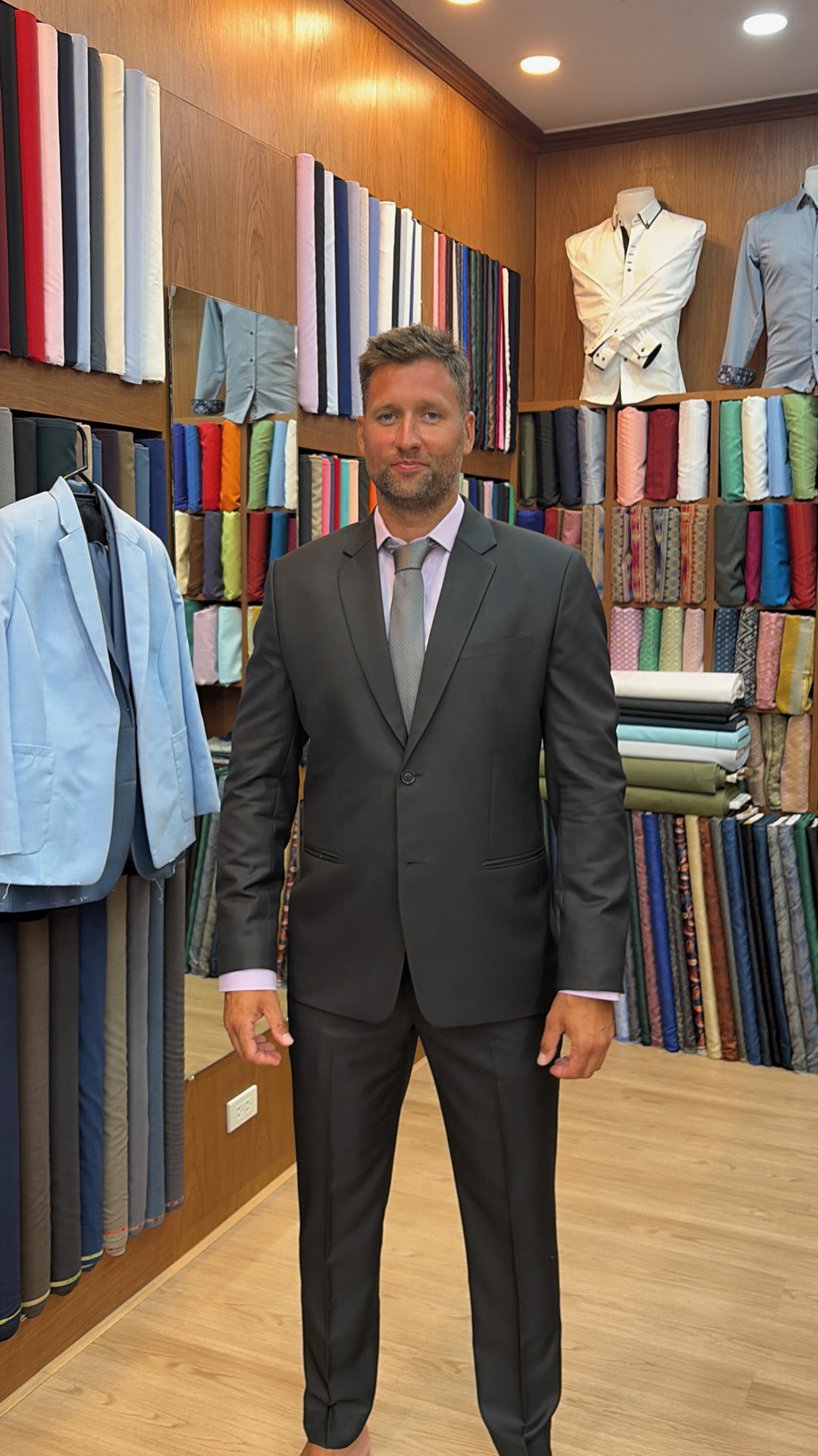 Client in a charcoal suit and pink shirt