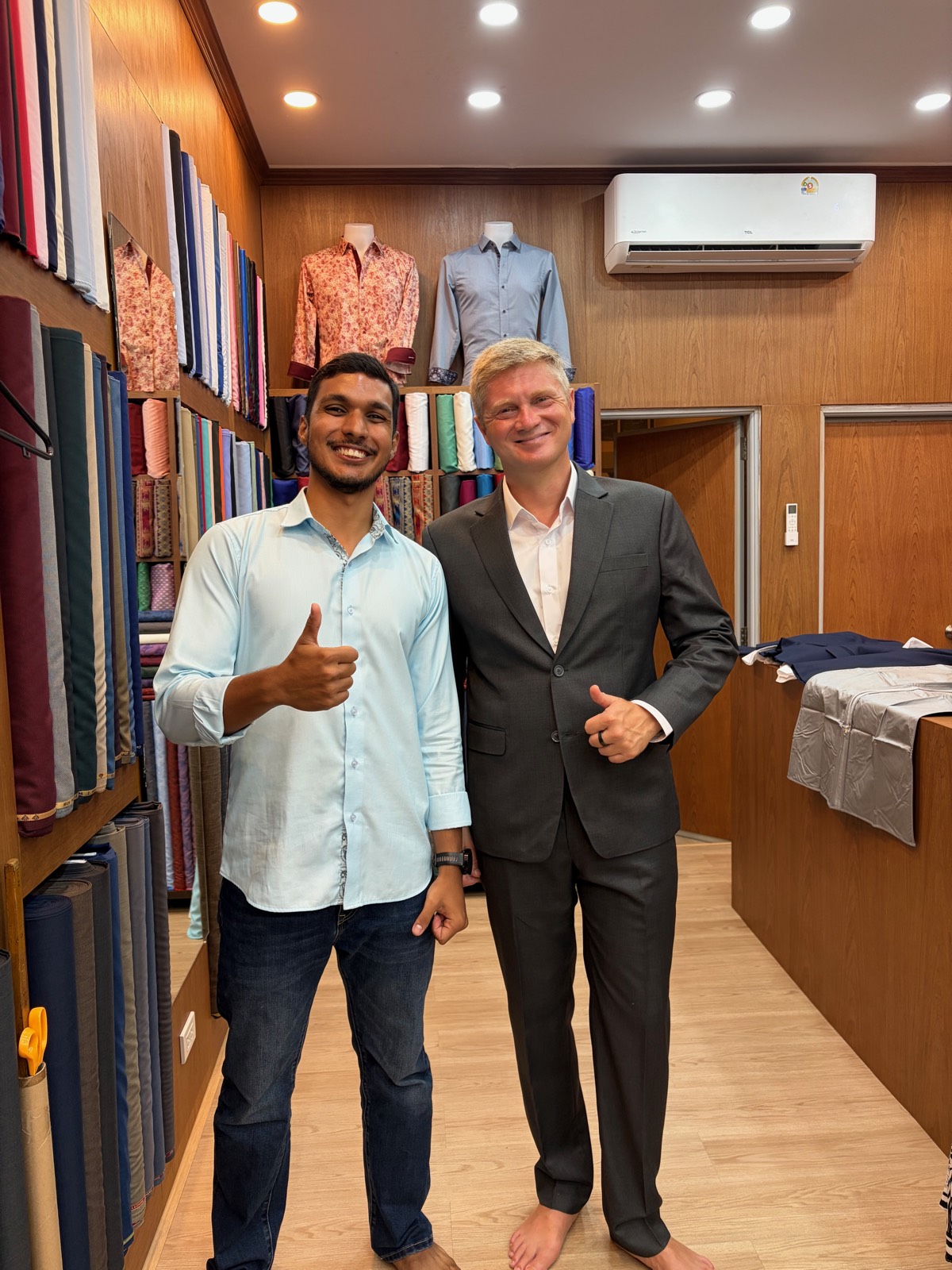 Client and tailor after a grey suit fitting